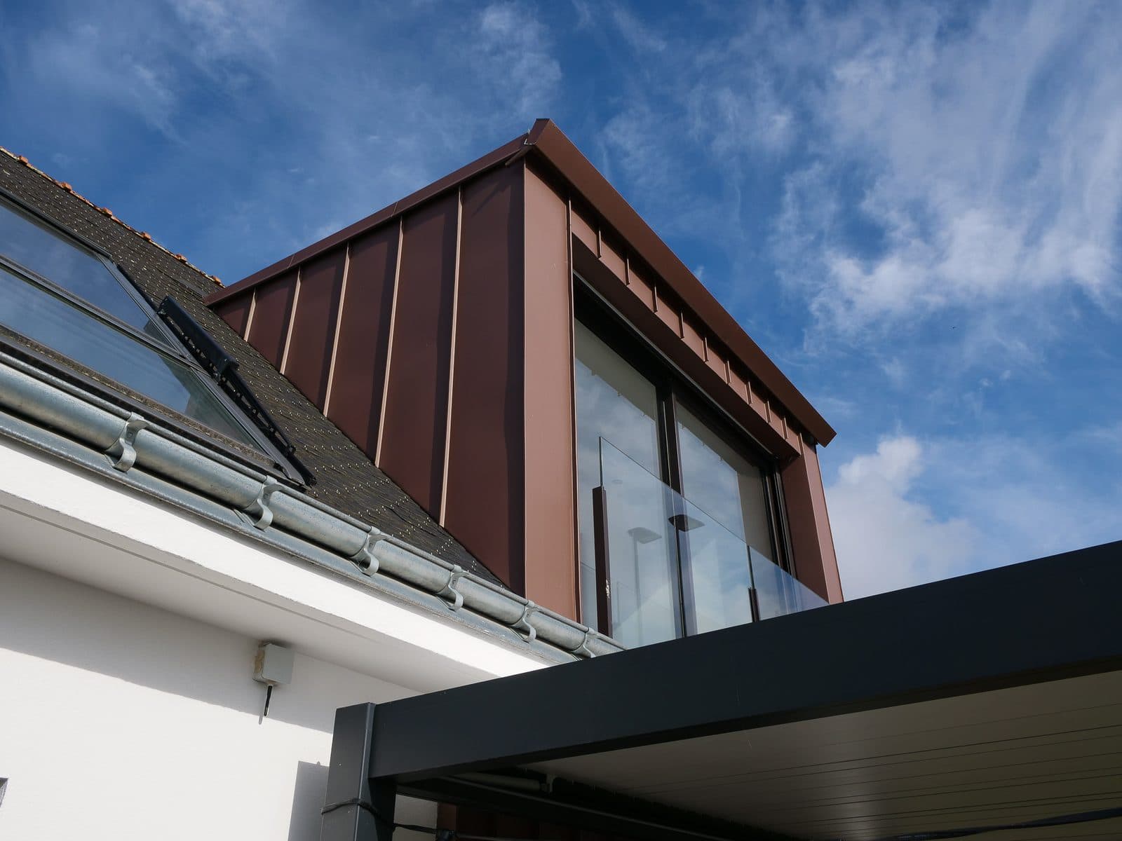Extension à bardage cuivré vue en contre-plongée sur ciel bleu