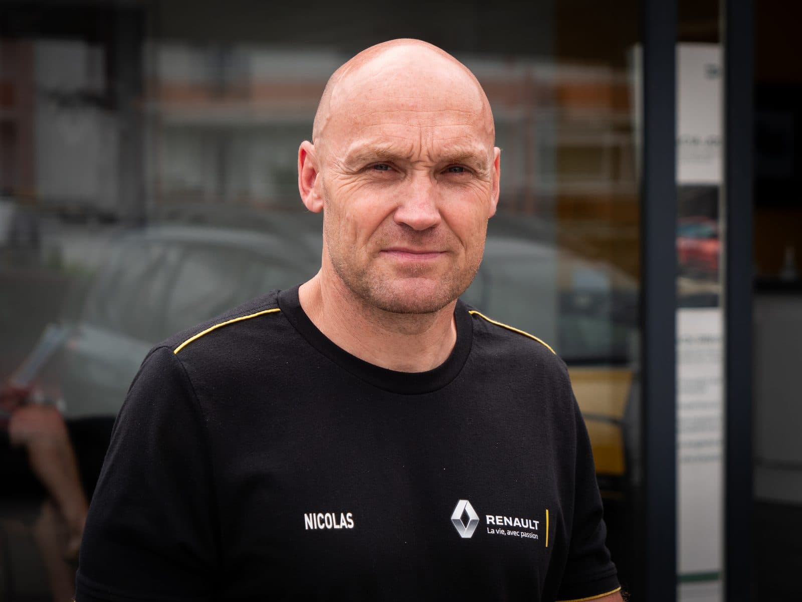 Portrait d’un collaborateur de garage en polo Renault devant la concession