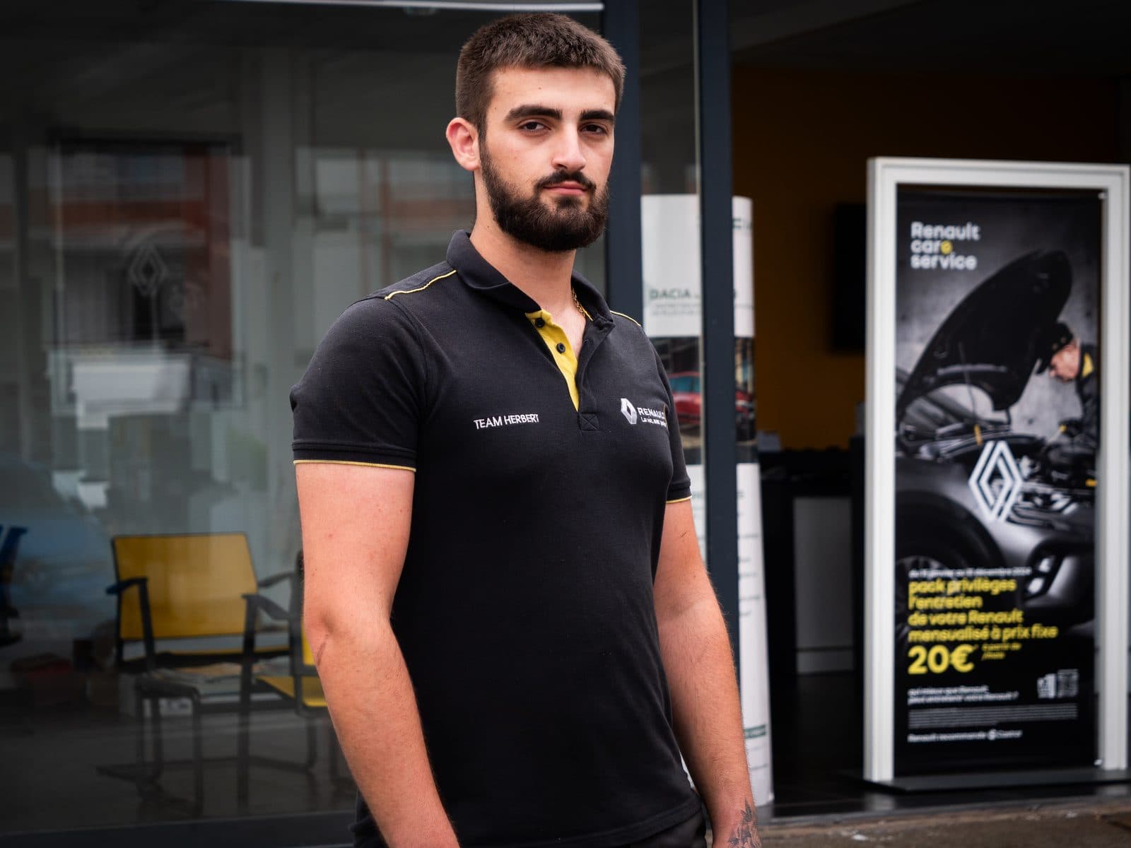 Portrait en pied d’un jeune technicien devant la concession