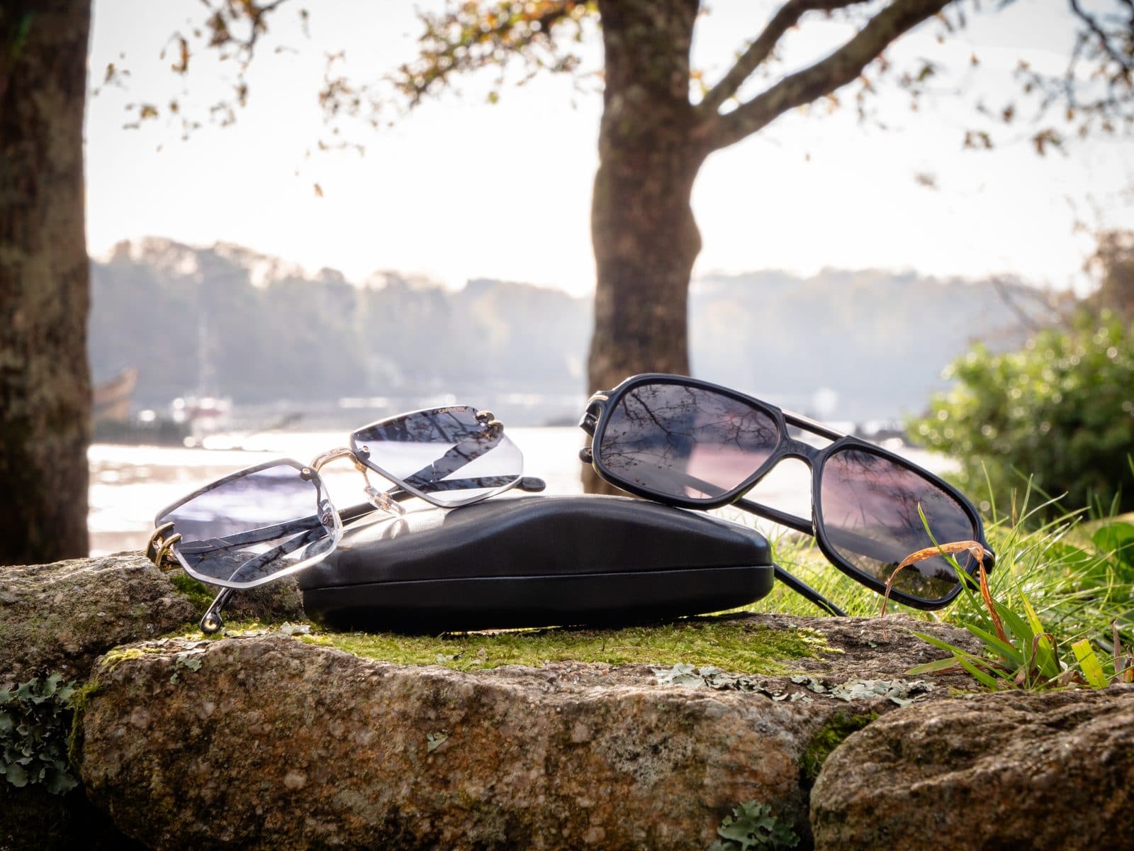 Lunettes de soleil et étui posés sur un rocher au bord de l’eau