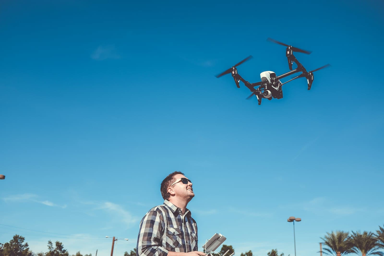 Télépilote faisant voler un drone dans un ciel bleu