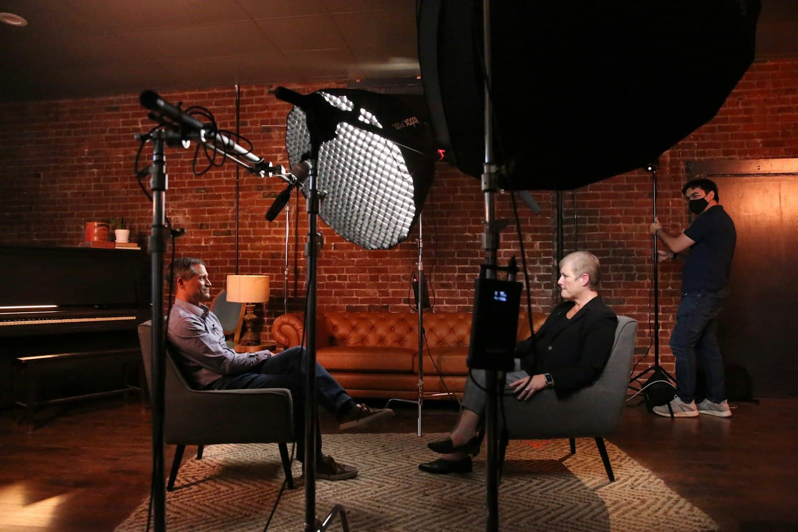 Interview filmée en studio, deux personnes assises face à la caméra sous les projecteurs