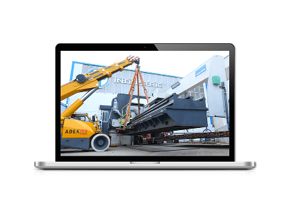 Vidéo de chantier : grue levant une pièce industrielle devant une usine